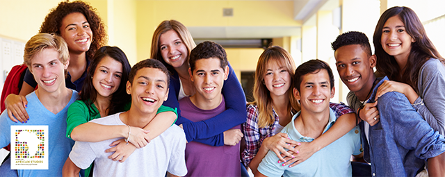 A diverse group of children/teenagers/young adults are smiling at the camera.